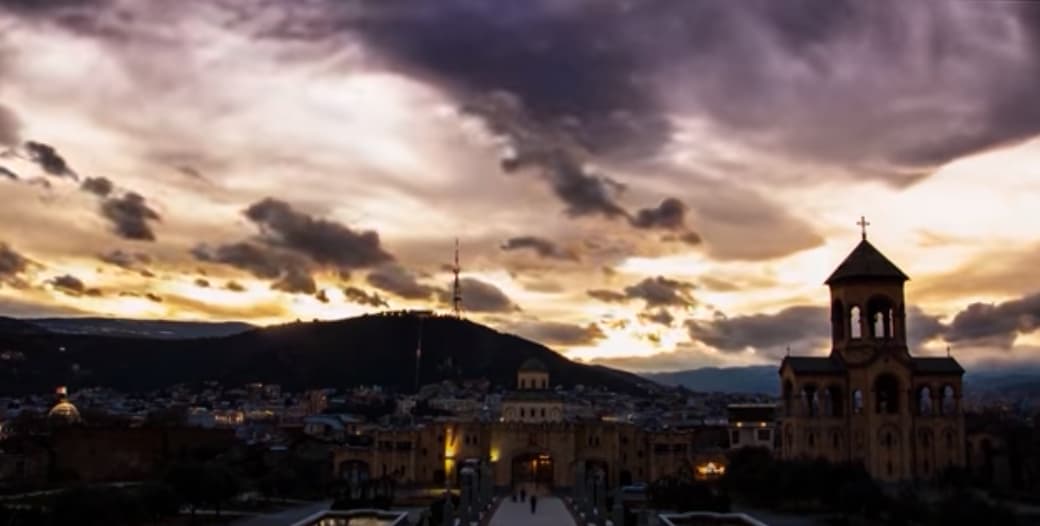 A Christian church with the evening city and mountains in the background