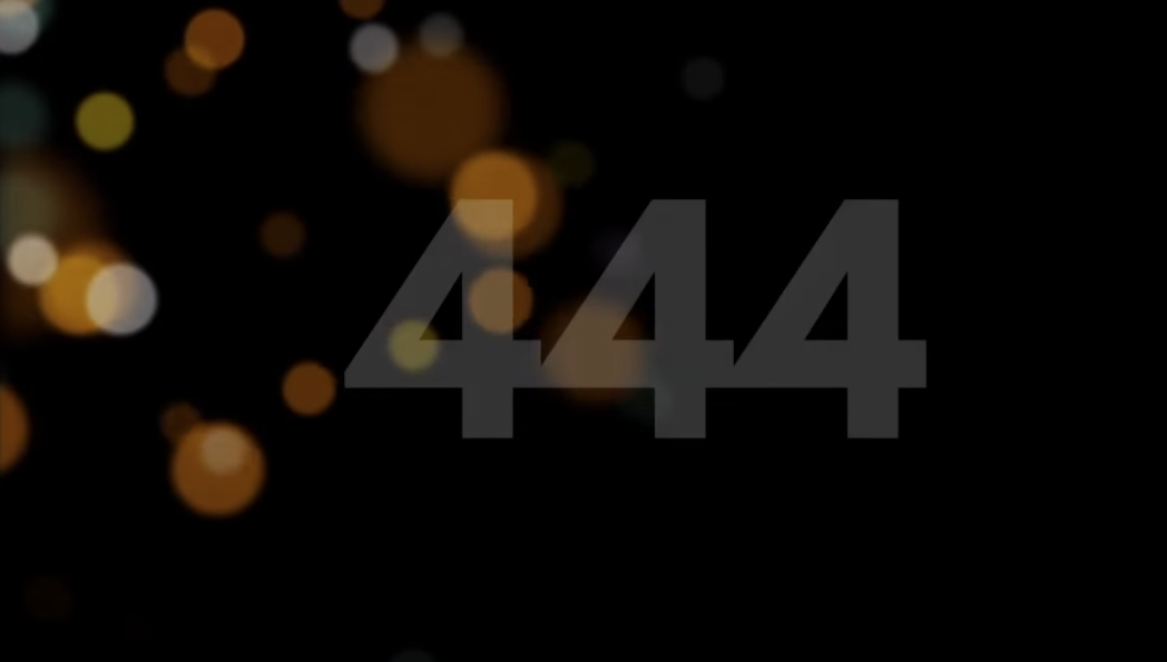 A dark background with glowing yellow lights in round shapes and a faint number "444" with low transparency