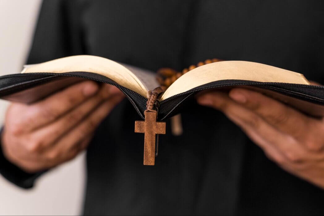 A man holding a Bible and a cross