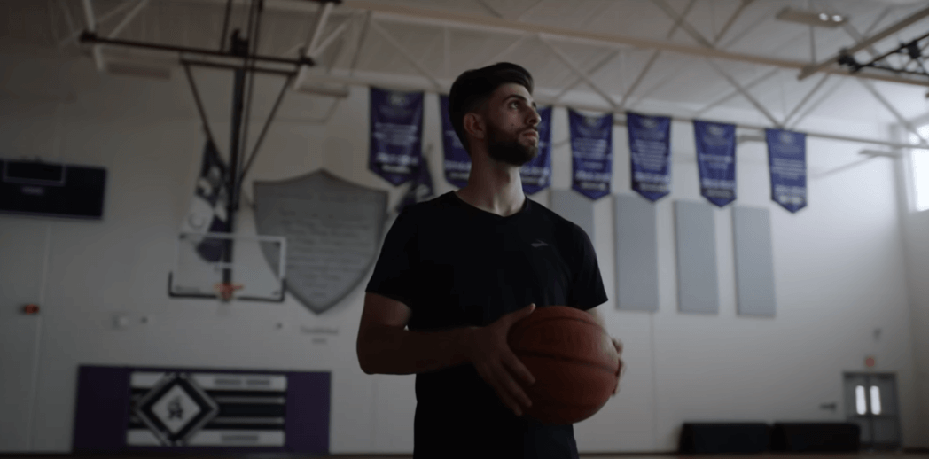 sypherpk with basketball in the gym and looking at the side