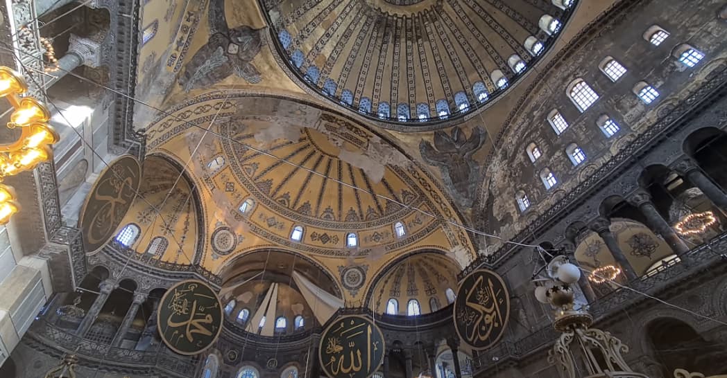 The Hagia Sophia: Mosaics at the ceiling showcasing Byzantine Empire's riches and devotion, depicting religious figures, rulers, and biblical scenes.