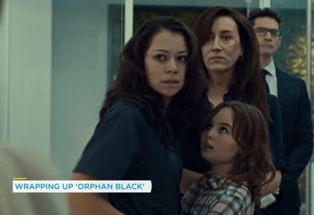 tatiana maslany standing with a girl, woman and man behind them  in orphan black