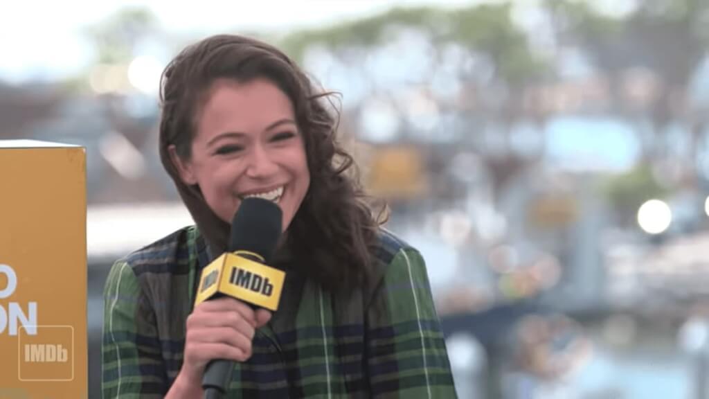 tatiana maslany in green shirt sitting with microphone and smiling