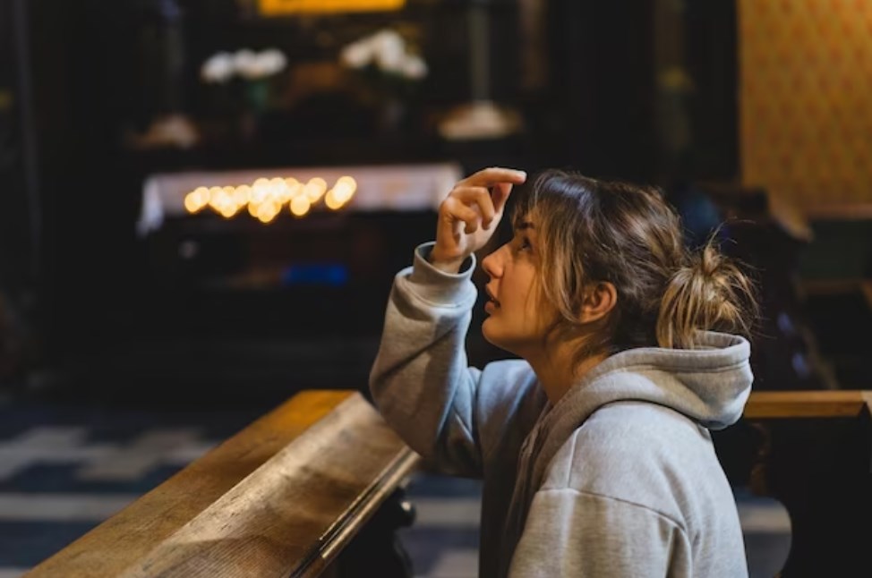 a woman praying on her knees in an ancient catholic temple